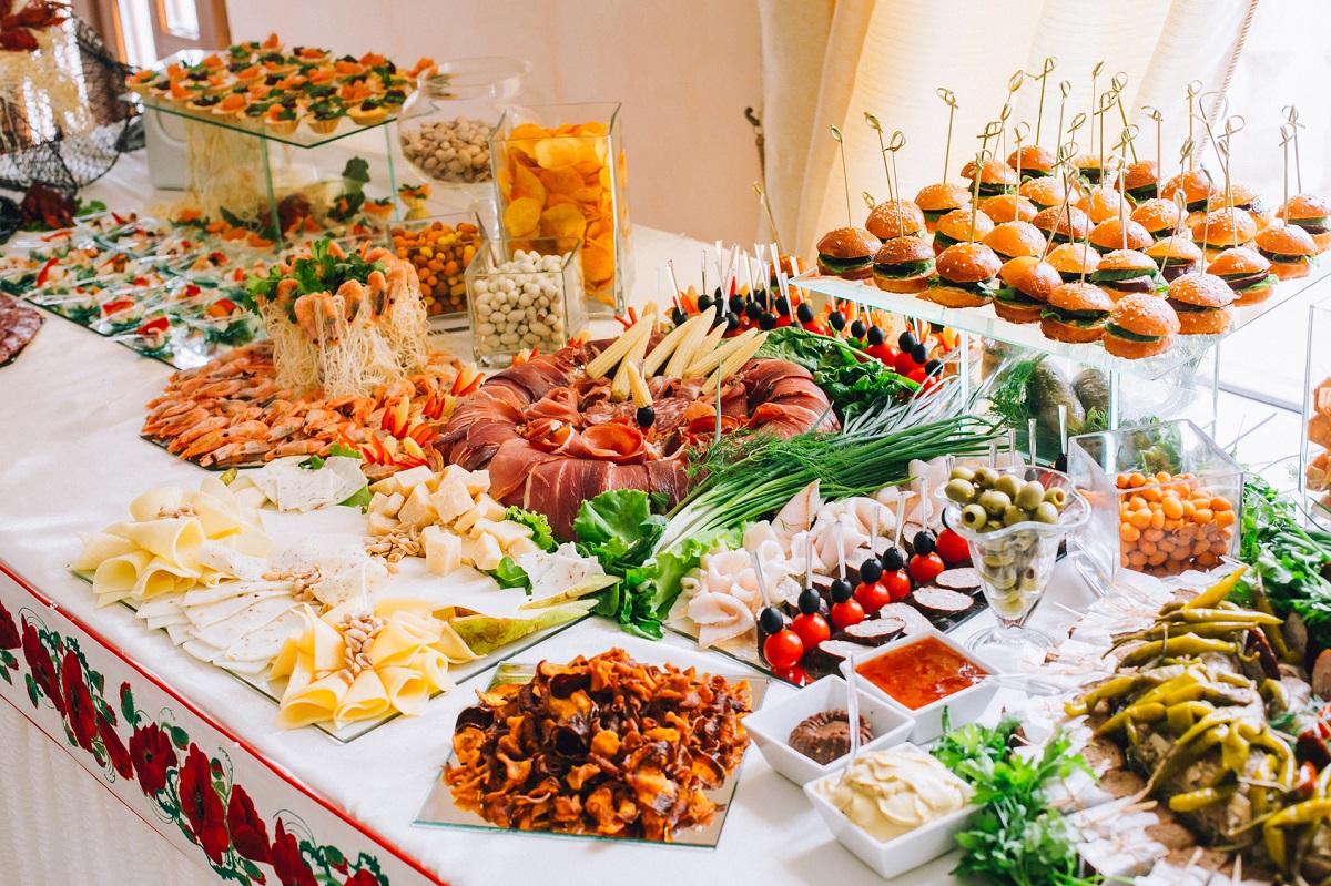 buffet table of reception with burgers, cold snacks, meat and salads